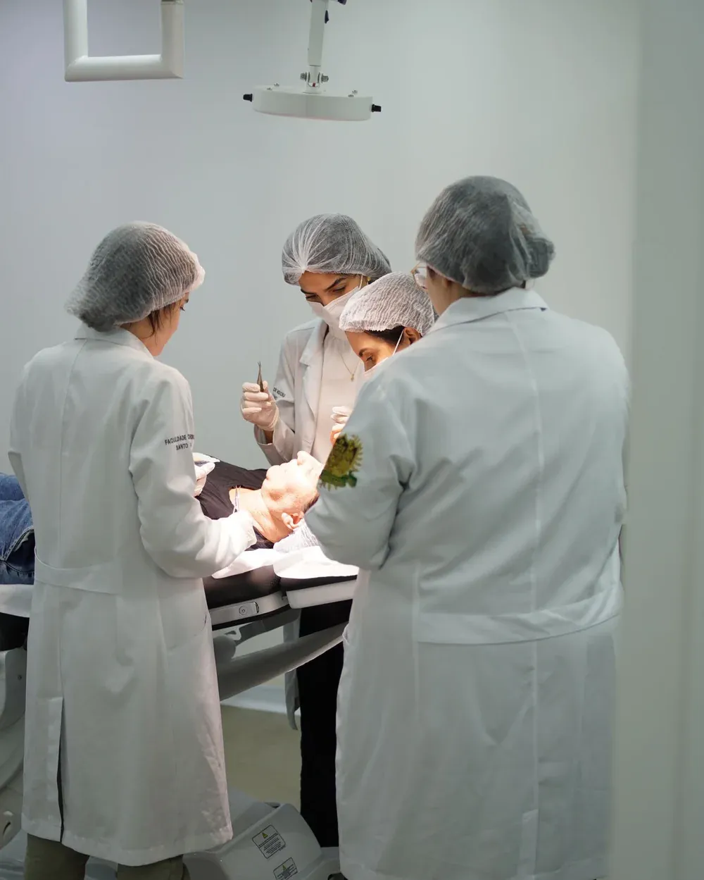 Professora médica da BWS no átrio da instituição, com estudantes ao fundo